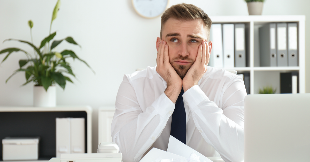 man sitting at desk looking distracted